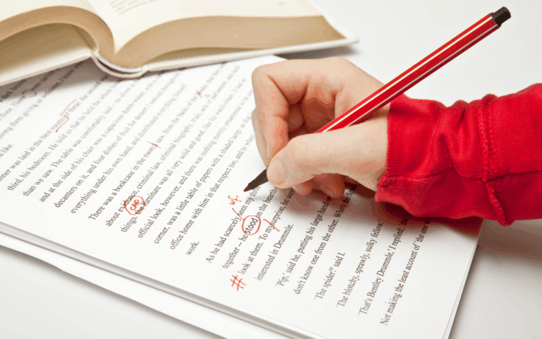 Hand korrigiert einen gedruckten Text mit rotem Stift – professionelles Lektorat und Textüberarbeitung
