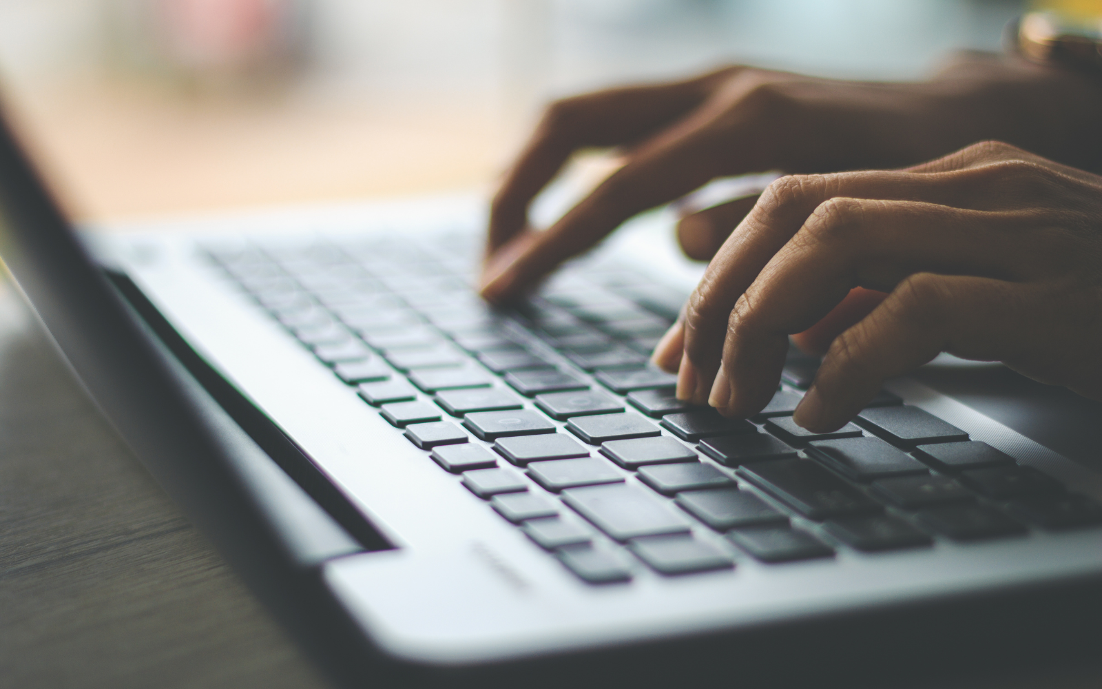 Hände tippen auf einer Laptop-Tastatur – professionelles Schreiben und Ghostwriting am Computer
