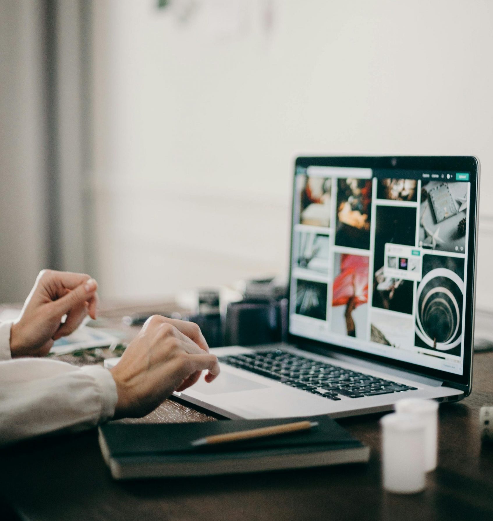 Person arbeitet am Laptop mit visuellen Inspirationsbildern auf dem Bildschirm – kreativer Schreib- und Konzeptionsprozess